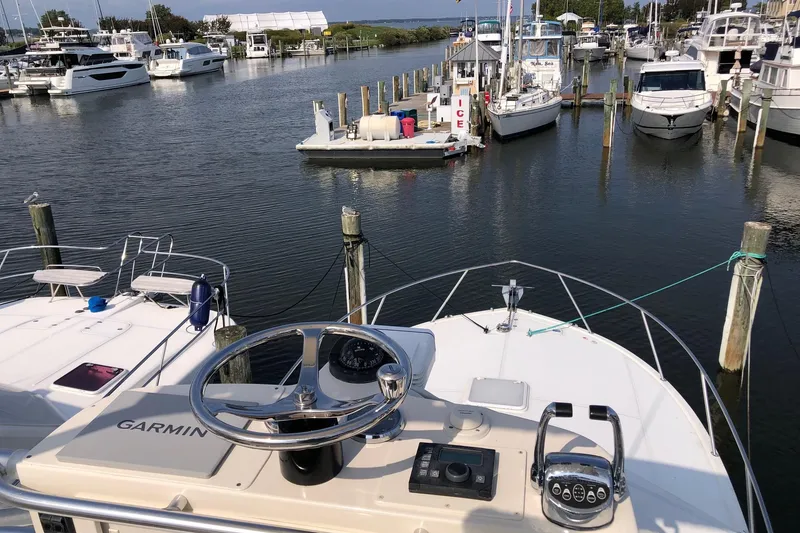 Slide: The Image of 2007 Carolina Classic 35 Express boat docked in a marina, featuring Garmin navigation equipment. - 13
