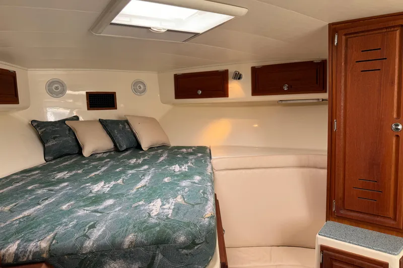 Slide: The Image of 2007 Carolina Classic 35 Express cabin interior with bed, pillows, and wooden cabinets. - 16