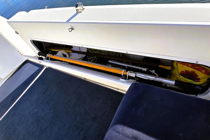 Slide: The Image of Storage compartment on a 2000 Bayliner 2858 Ciera Command Bridge boat, containing various tools. - 28