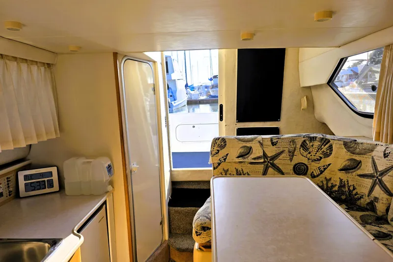 Slide: The Image of Interior of 2000 Bayliner 2858 Ciera Command Bridge with nautical-themed seating and kitchenette. - 3