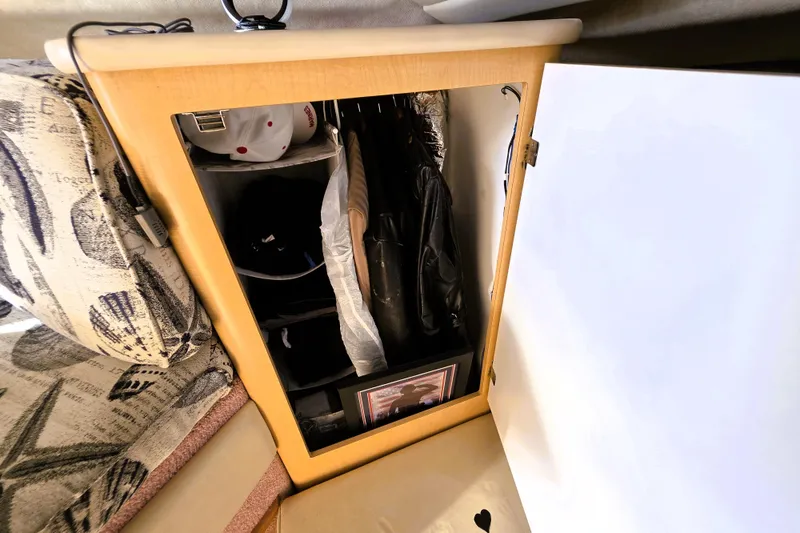 Slide: The Image of Storage cabinet inside 2000 Bayliner 2858 Ciera Command Bridge, featuring hanging clothes and accessories. - 36