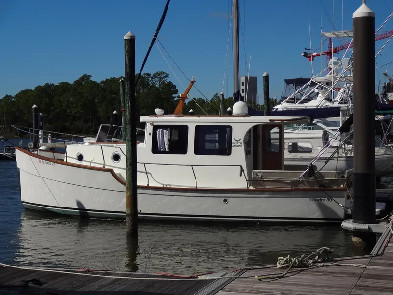 Slide: The Image of 2016 North Aegean 30 Trawler docked at marina, calm water, blue sky. - 4