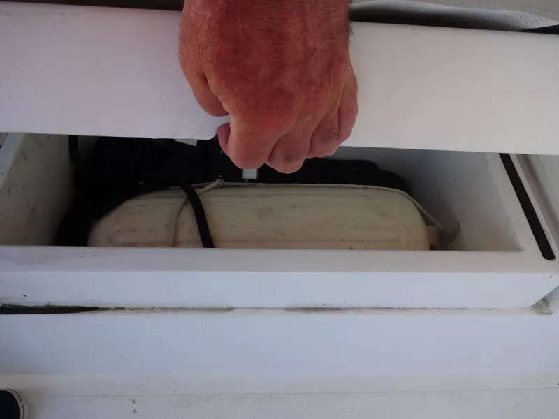 Slide: The Image of Hand opening storage compartment on a 2016 North Aegean 30 boat. - 49
