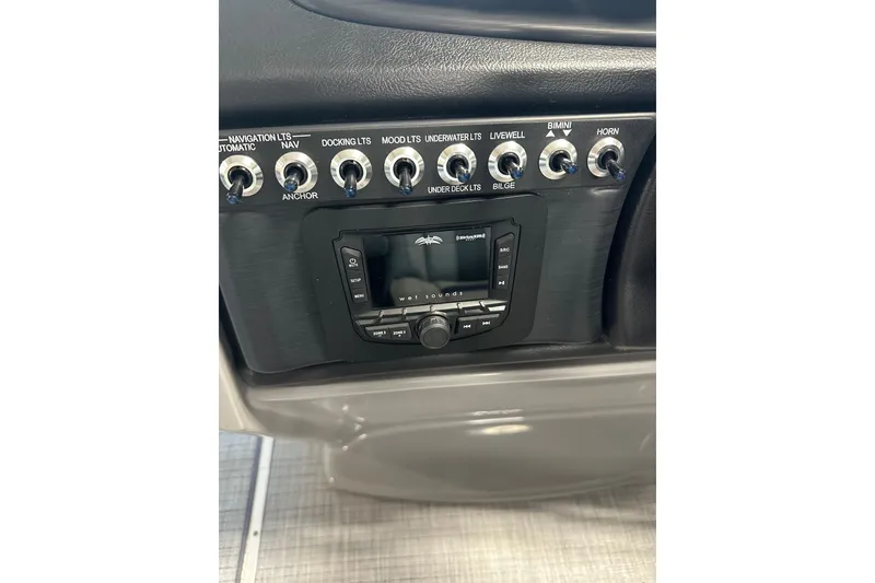 Slide: The Image of Control panel of 2025 Trifecta 24RFCS3 boat with switches and audio system. - 13