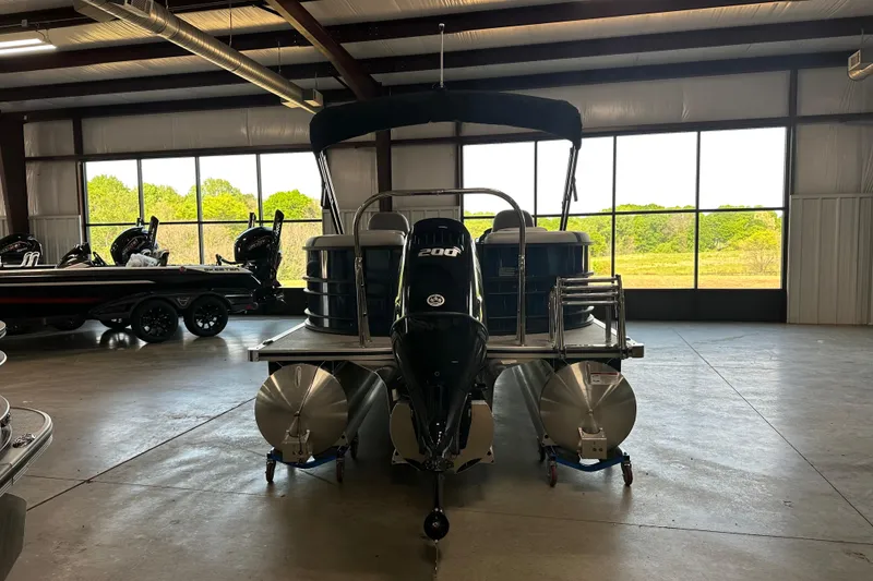 Slide: The Image of 2025 Trifecta 24RFCS3 pontoon boat with 200 horsepower engine in a showroom. - 3