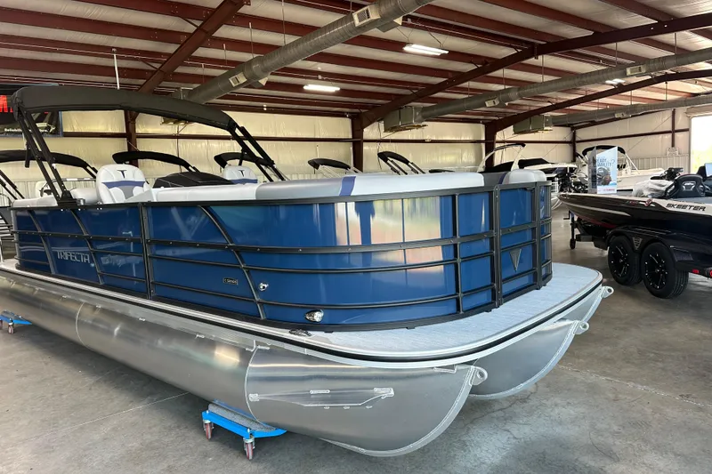 Slide: The Image of 2025 Trifecta 24RFCS3 pontoon boat in showroom, featuring sleek blue design and modern seating. - 5