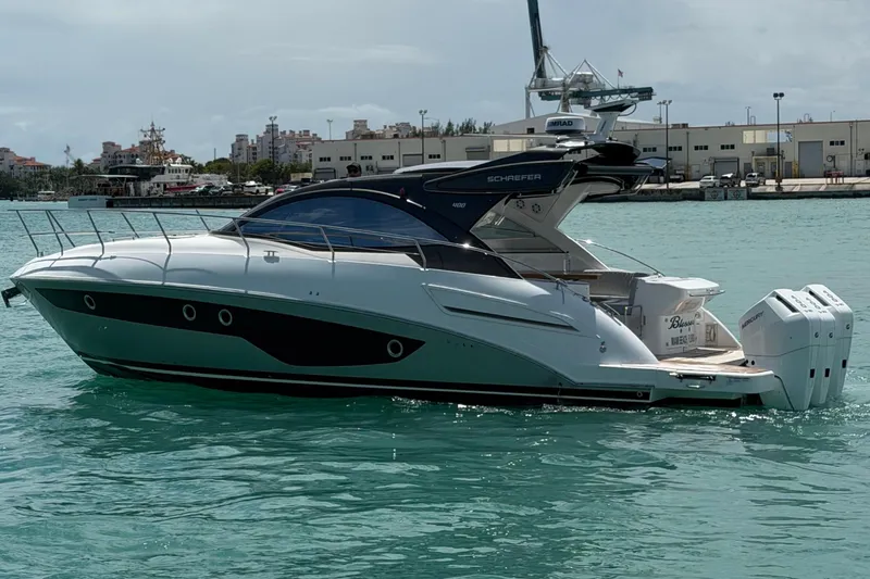Slide: The Image of 2024 Schaefer 400 yacht on turquoise water near a marina. - 2