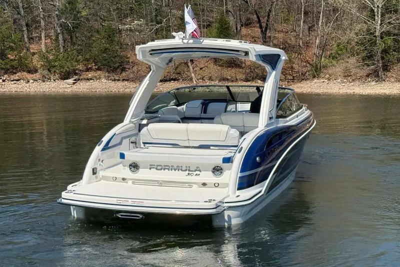 Slide: The Image of 2026 Formula 310 Bowrider I/O boat on a calm lake, surrounded by trees. - 14