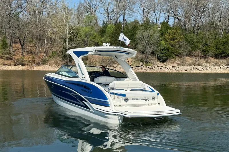 Slide: The Image of 2026 Formula 310 Bowrider I/O cruising on a calm lake with wooded shoreline. - 3