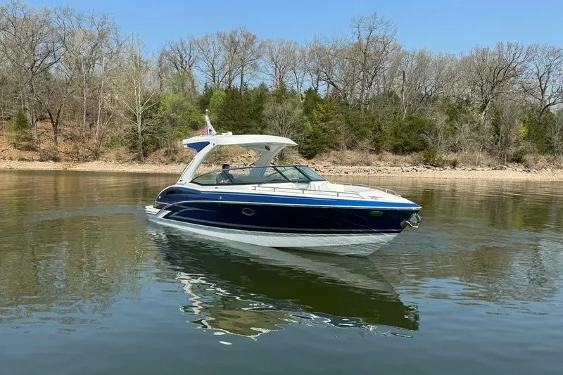 Slide: The Image of 2026 Formula 310 Bowrider I/O cruising on a calm lake with wooded shoreline. - 30