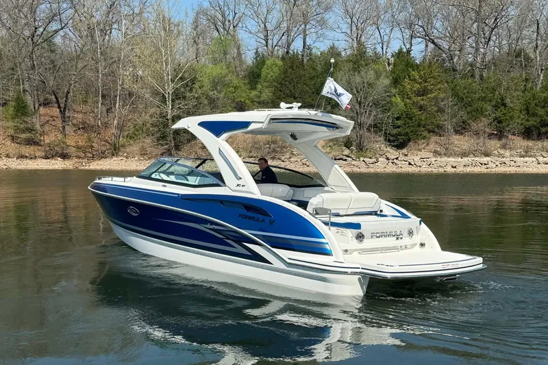 Slide: The Image of 2026 Formula 310 Bowrider I/O cruising on a calm lake with wooded shoreline. - 4