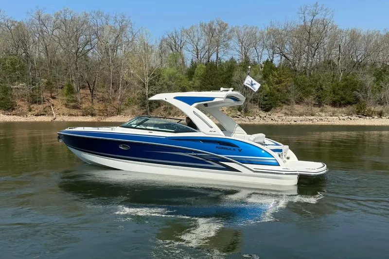 Slide: The Image of 2026 Formula 310 Bowrider I/O boat on calm water, surrounded by trees. - 5