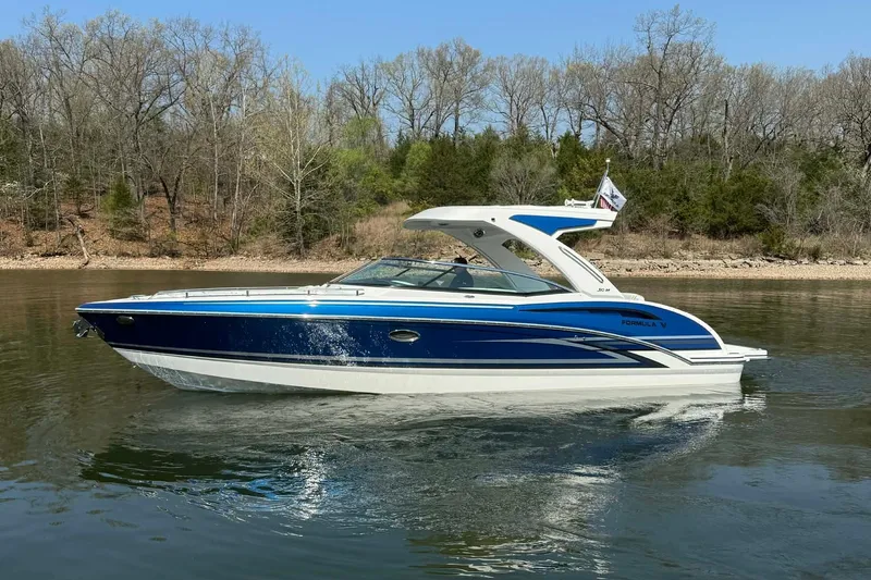Slide: The Image of 2026 Formula 310 Bowrider I/O cruising on a calm lake with wooded shoreline. - 7