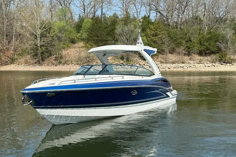 Slide: The Image of 2026 Formula 310 Bowrider I/O boat on calm lake with forested shoreline. - 9