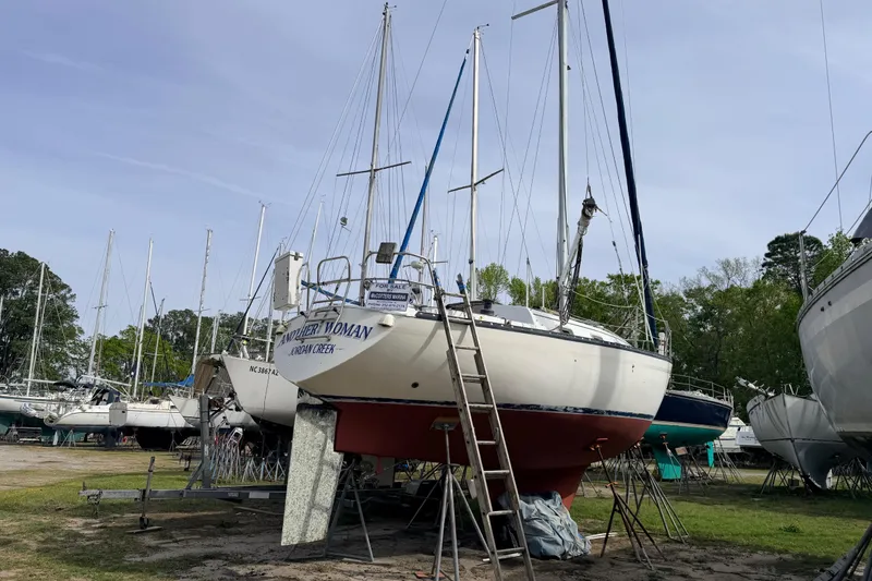 The Image of 1980 Hunter 37 Cherubini Cutter sailboat on land, surrounded by other boats. - 0