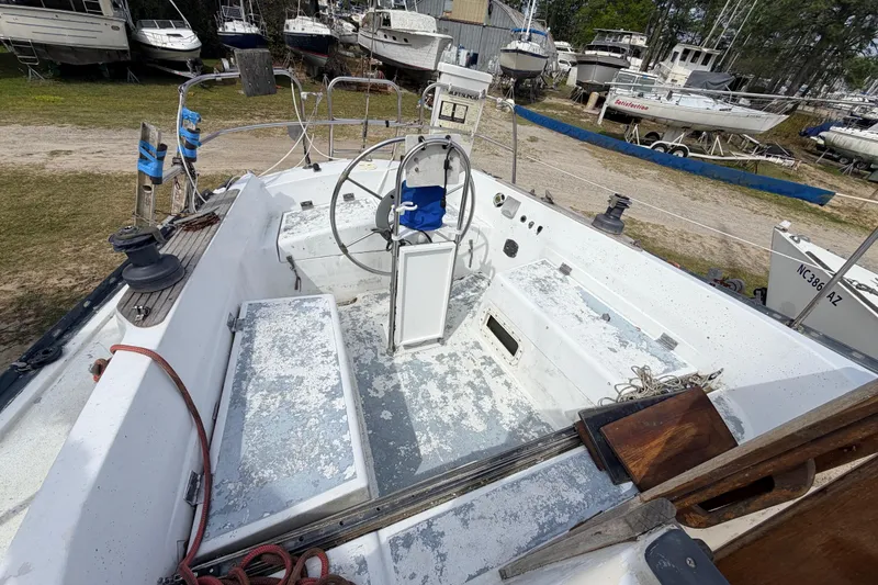 Slide: The Image of 1980 Hunter 37 Cherubini Cutter sailboat cockpit with steering wheel, docked among other boats. - 15