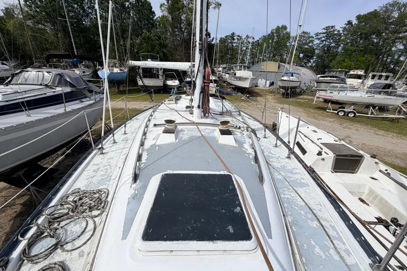 Slide: The Image of 1980 Hunter 37 Cherubini Cutter sailboat on land, surrounded by other boats. - 16