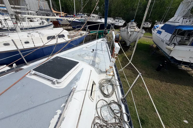 Slide: The Image of 1980 Hunter 37 Cherubini Cutter sailboat on land, surrounded by other boats. - 18