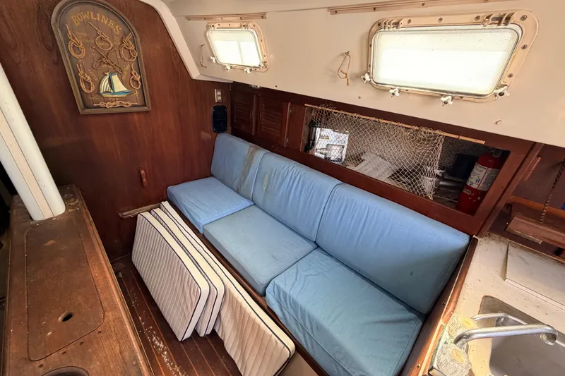 Slide: The Image of Interior of 1980 Hunter 37 Cherubini Cutter with blue cushions and nautical decor. - 27