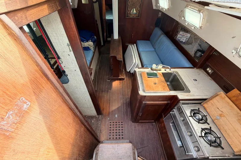 Slide: The Image of Interior of a 1980 Hunter 37 Cherubini Cutter yacht with kitchen and seating area. - 33