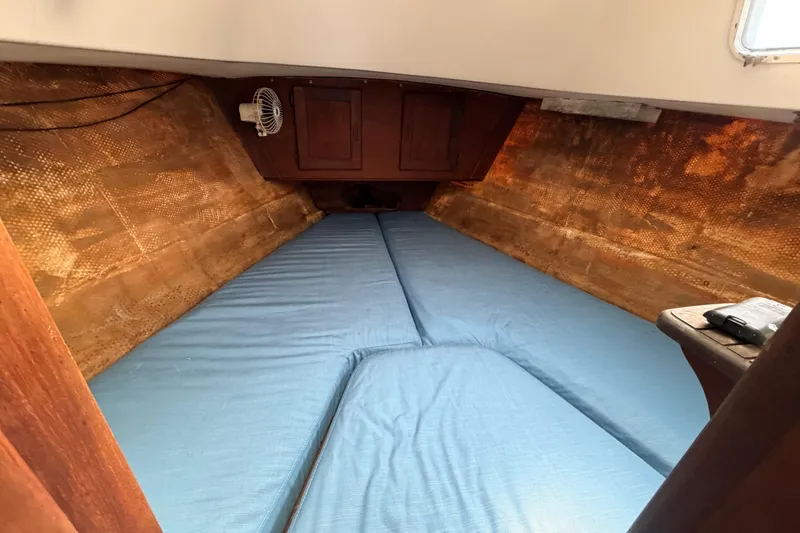 Slide: The Image of Interior cabin of 1980 Hunter 37 Cherubini Cutter with blue bedding and wooden accents. - 35