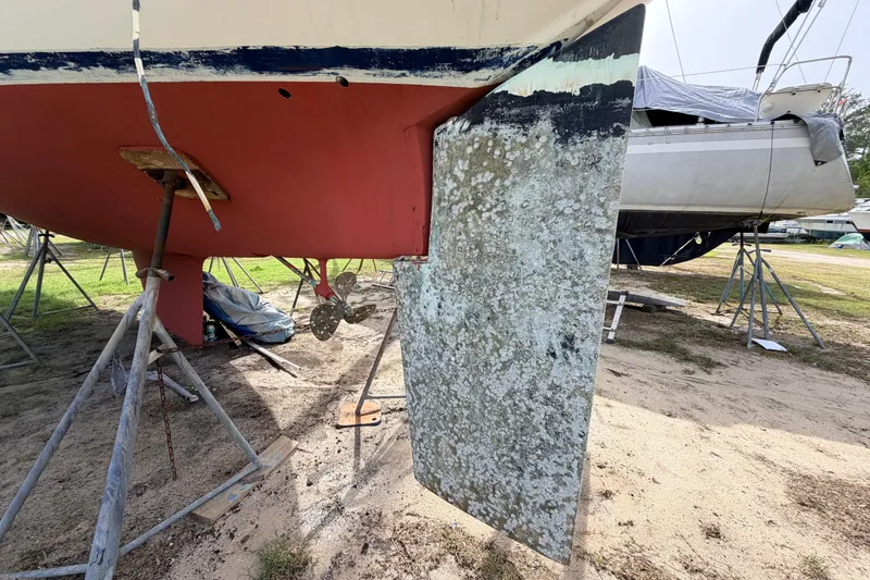 Slide: The Image of 1980 Hunter 37 Cherubini Cutter sailboat on stands, showing hull and rudder details. - 7