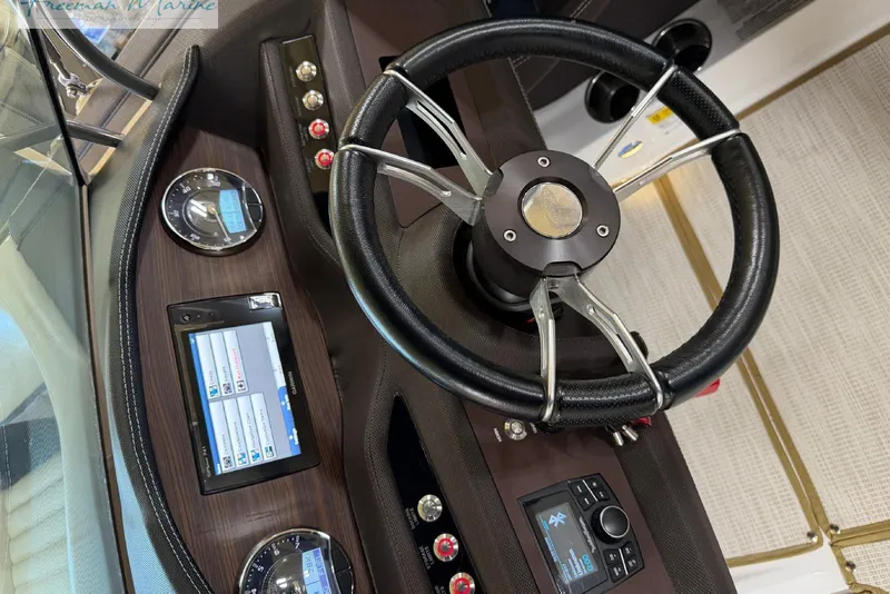 Slide: The Image of Steering wheel and dashboard of 2016 Marker One M25 boat, featuring modern controls and displays. - 14