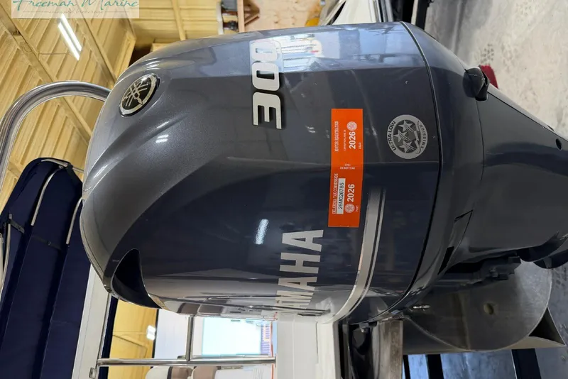 Slide: The Image of Outboard motor on a 2016 Marker One M25 boat in a wooden garage. - 18