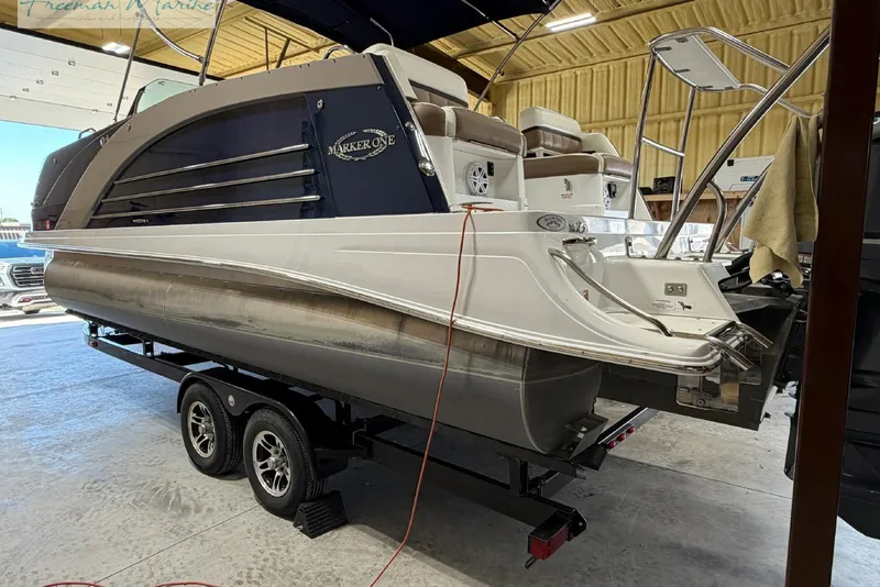 Slide: The Image of 2016 Marker One M25 pontoon boat on trailer in indoor storage facility. - 19