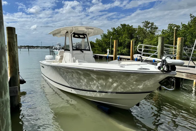 Slide: The Image of 2022 Regulator 28 boat docked in calm waters under a partly cloudy sky. - 17