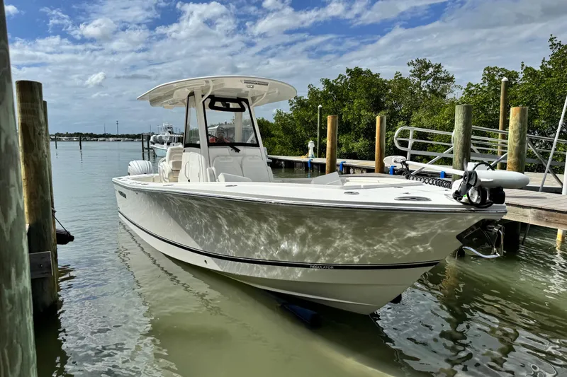 Slide: The Image of 2022 Regulator 28 boat docked in calm waters under a partly cloudy sky. - 19