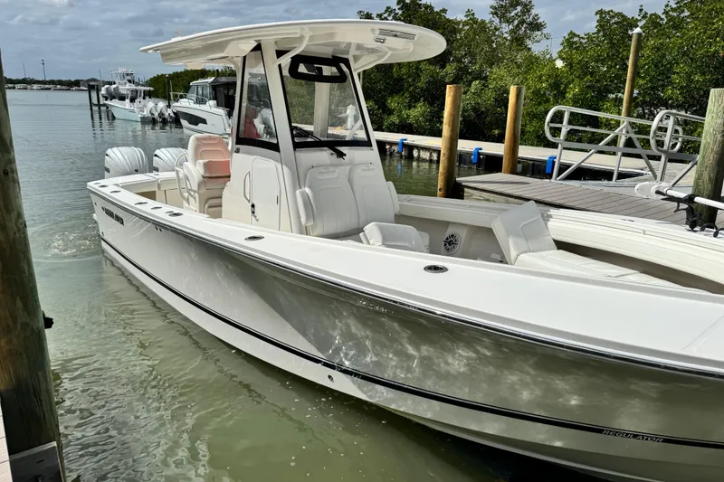 Slide: The Image of 2022 Regulator 28 boat docked in a serene marina setting. - 20