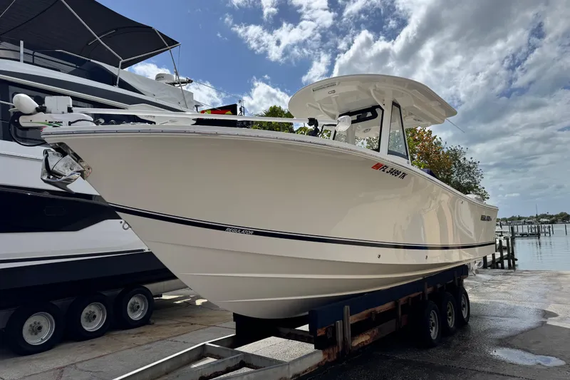 Slide: The Image of 2022 Regulator 28 boat on trailer at marina under cloudy sky. - 21