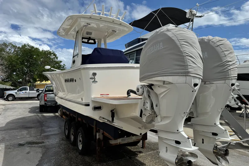 Slide: The Image of 2022 Regulator 28 boat with dual Yamaha engines on a trailer, parked outdoors. - 23