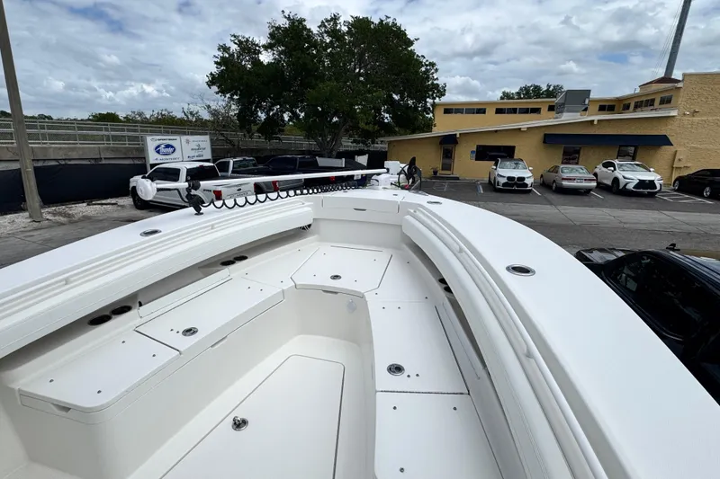 Slide: The Image of 2022 Regulator 28 boat with spacious deck, parked near a building and cars. - 28