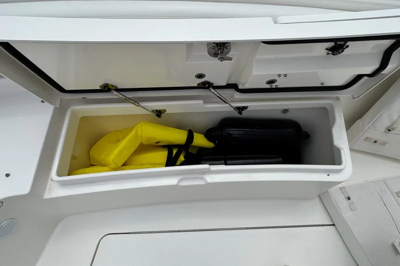 Slide: The Image of Open storage compartment on 2022 Regulator 28 boat with life jacket and gear. - 30