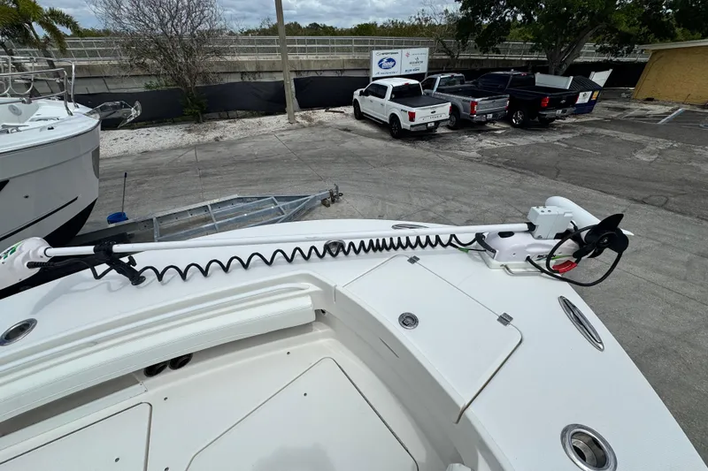 Slide: The Image of 2022 Regulator 28 boat with trolling motor, parked near trucks and trailers. - 32