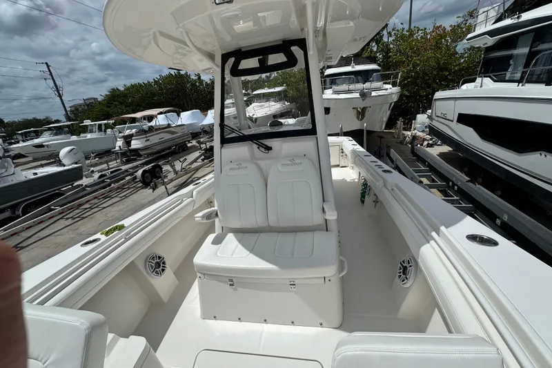 Slide: The Image of 2022 Regulator 28 boat interior with seating, docked among other boats. - 37
