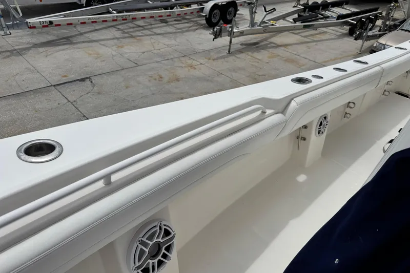 Slide: The Image of 2022 Regulator 28 boat interior with rod holders and speakers, docked on a trailer. - 40