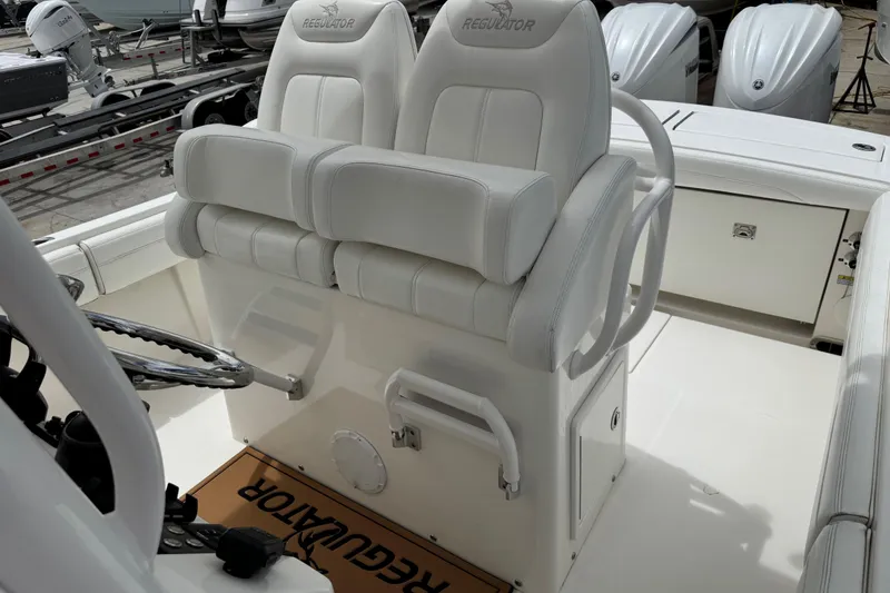 Slide: The Image of 2022 Regulator 28 boat interior with dual white cushioned seats and steering wheel. - 43