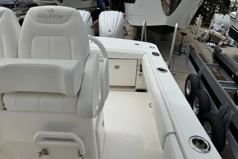 Slide: The Image of 2022 Regulator 28 boat interior with white seating and storage compartments. - 44