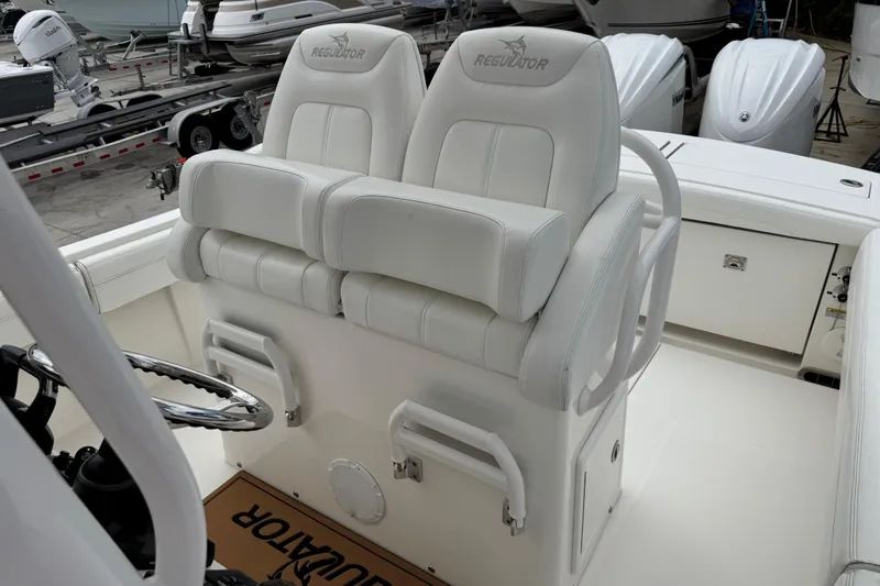 Slide: The Image of 2022 Regulator 28 boat with dual white cushioned seats and steering wheel. - 45