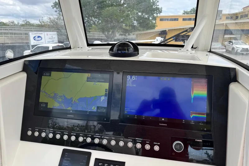 Slide: The Image of 2022 Regulator 28 boat dashboard with dual Garmin displays and navigation controls. - 47