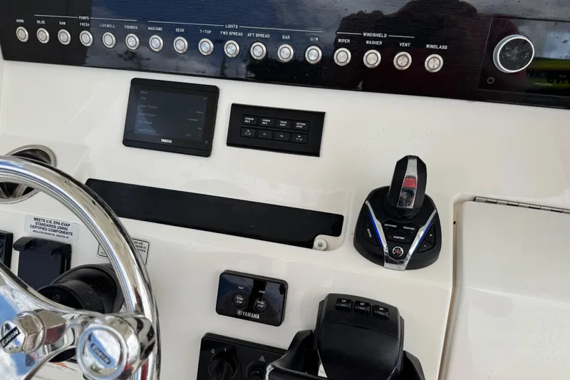 Slide: The Image of Control panel of a 2022 Regulator 28 boat with Yamaha controls and switches. - 48