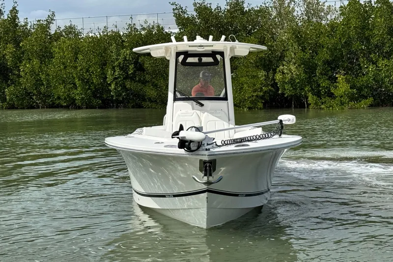 Slide: The Image of 2022 Regulator 28 boat navigating through calm waters near lush greenery. - 5