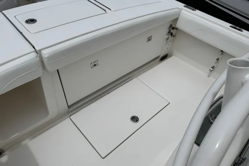 Slide: The Image of 2022 Regulator 28 boat interior with white seating and storage compartments. - 53