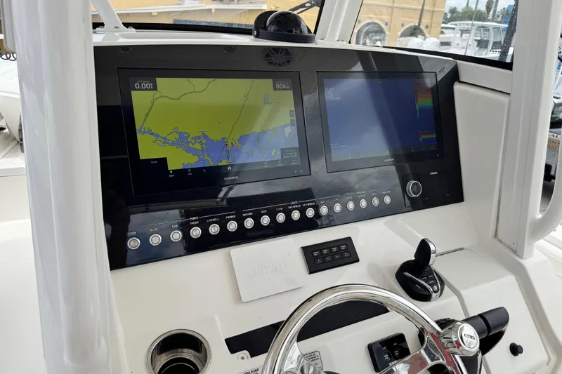 Slide: The Image of 2022 Regulator 28 boat dashboard with dual Garmin displays and control panel. - 57