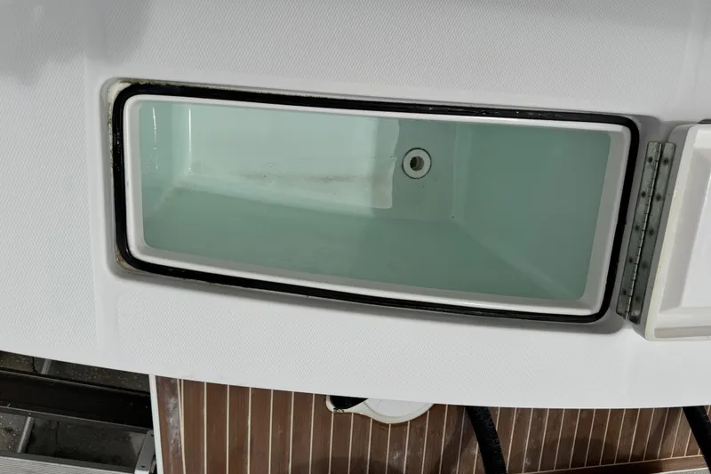 Slide: The Image of Livewell compartment on a 2022 Regulator 28 boat, featuring a clean, white interior. - 58