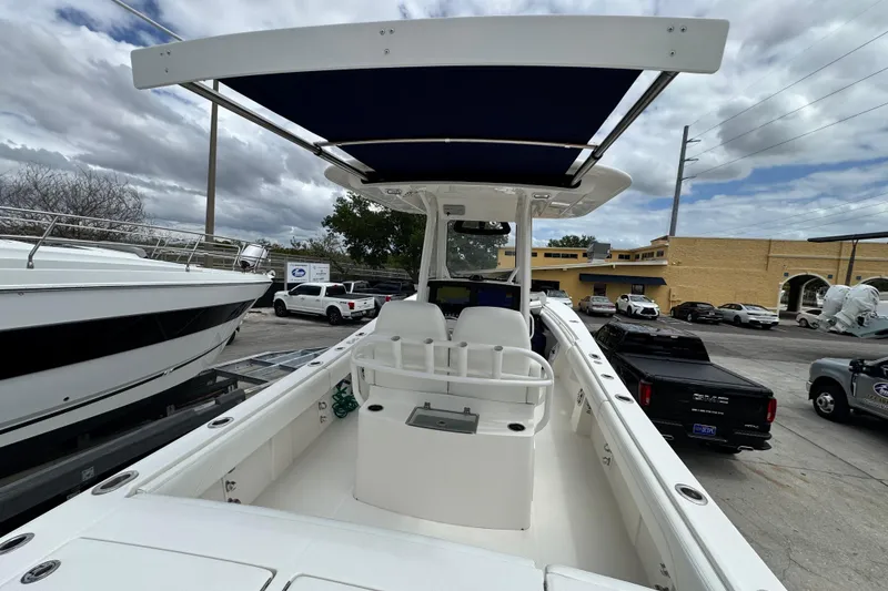 Slide: The Image of 2022 Regulator 28 boat with T-top, docked in a marina under cloudy skies. - 63