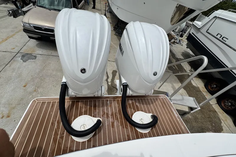 Slide: The Image of Twin Yamaha outboard engines on a 2022 Regulator 28 boat, docked on a wooden platform. - 65